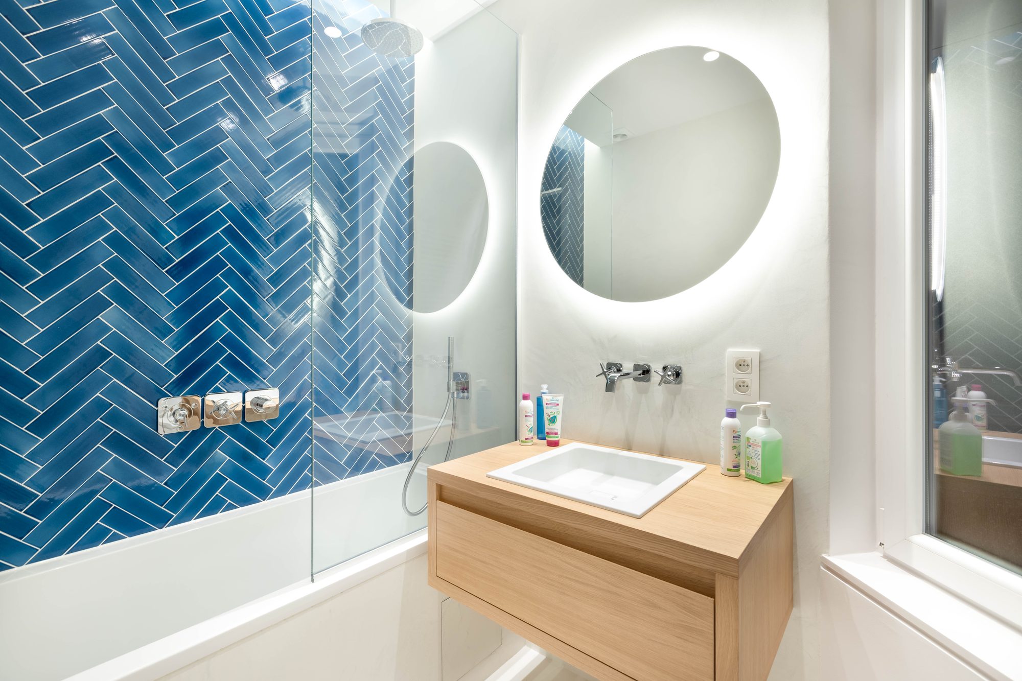 Brugmann 17 — La salle de bain bleue, de nuit — zellige en chevron, miroir en halo