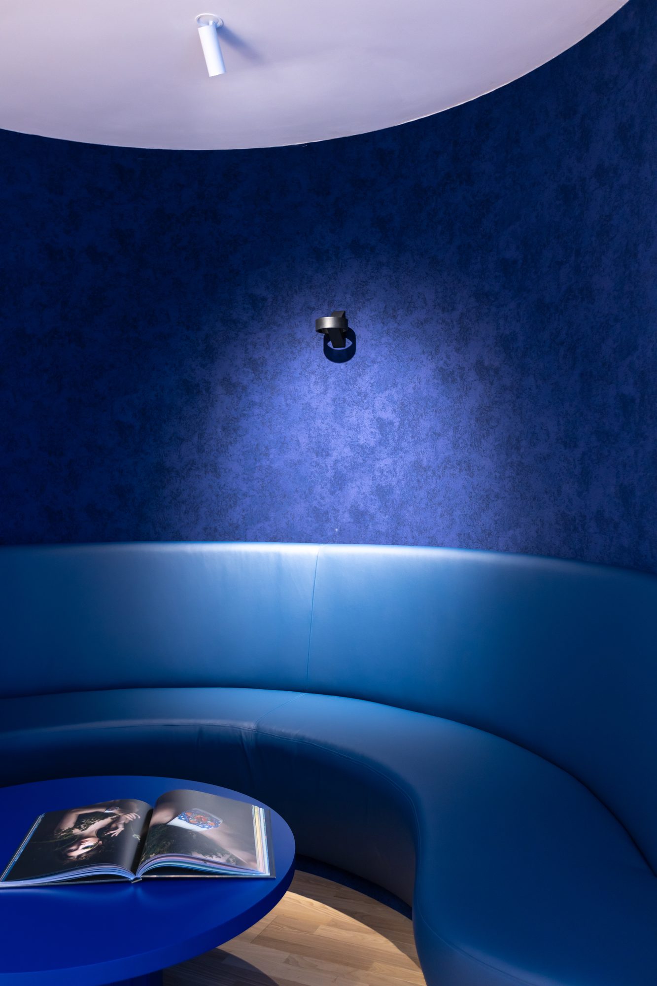 Brugmann 421 — Cabine immersive — banquette anneau cuir bleu, mur suédé bleu nuit