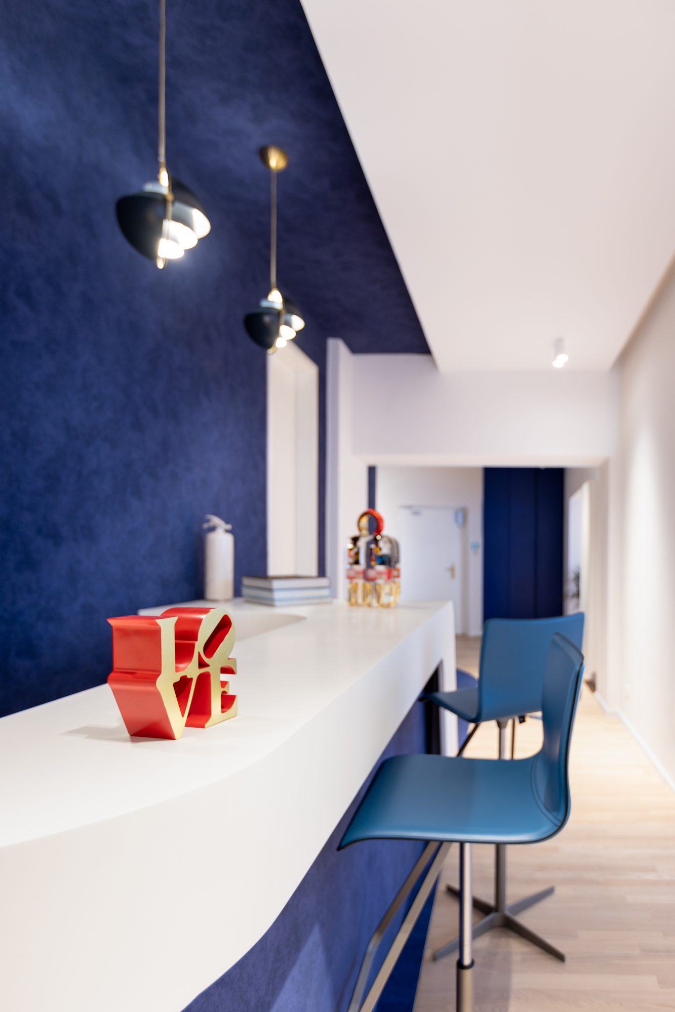 Brugmann 421 — Le comptoir d'accueil blanc laqué — la sculpture LOVE en accent