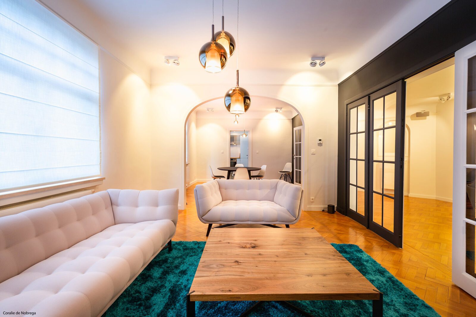 Puressentiel Appartement — Le salon — canapé capitonné, arche et parquet point de Hongrie